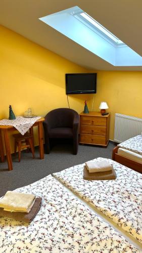 a room with two beds and a flat screen tv at Villa Victoria Penzion in Liptovský Ján
