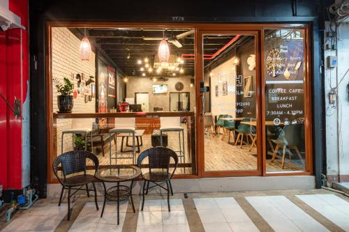 a table and chairs in front of a restaurant at The Dorm Hostel in Ban Lo Long