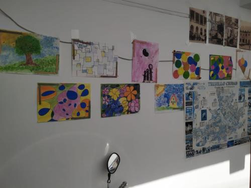 a wall with paintings hanging on a wall at Ambigua Hospedaje in Trujillo