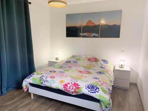 a bedroom with a bed with a floral comforter at Gîte Camdeborde 2 personnes au cœur du village de Laruns in Laruns