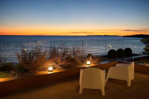 a patio with a view of the ocean at sunset at Villa Gloss Primosten in Primošten