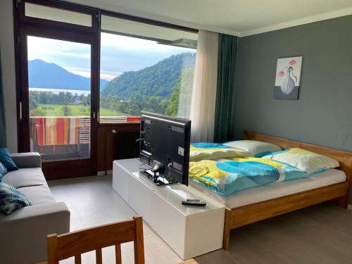 シュトローブルにあるSchöne Ferienwohnung mit Wolfgangseeblickのベッドルーム(ベッド1台、デスク、テレビ付)