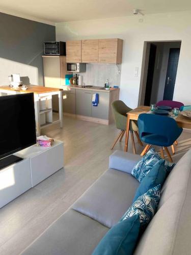a living room with a couch and a table and a kitchen at Schöne Ferienwohnung mit Wolfgangseeblick in Strobl