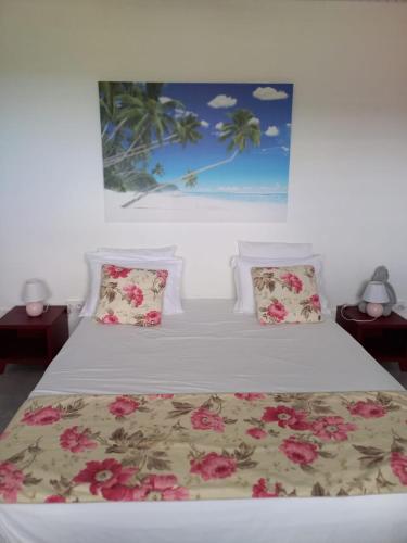 a bedroom with a bed with pink flowers on it at Le DAMOUR Appartement 1 ou 2 chambres in Les Anses-dʼArlets