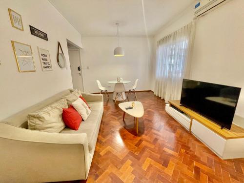 sala de estar con sofá, TV y mesa en Mdz Apartments en Mendoza