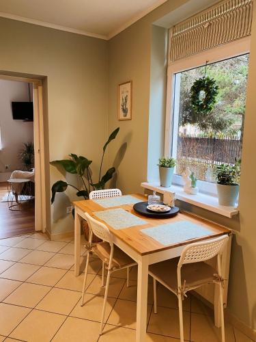 a dining room with a table and chairs and a window at Apartamenty Jagodzianka - Jacuzzi, Sauna, Tężnia solankowa in Ustrzyki Dolne