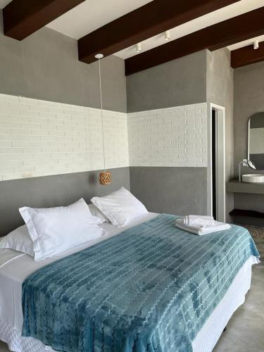 a bedroom with a large bed with a blue blanket at Villa dos Ganchos in Governador Celso Ramos