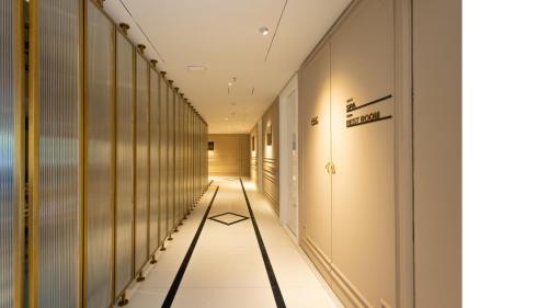 a hallway with white tile flooring and a long corridor at Renest Calangute Goa in Calangute