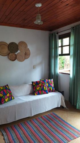 een slaapkamer met een bed, een raam en een tapijt bij Casa da Roça in Visconde De Maua