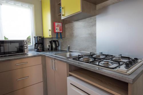 une cuisine avec un évier et une cuisinière dans l'établissement le 934 des charmettes, aux Mathes