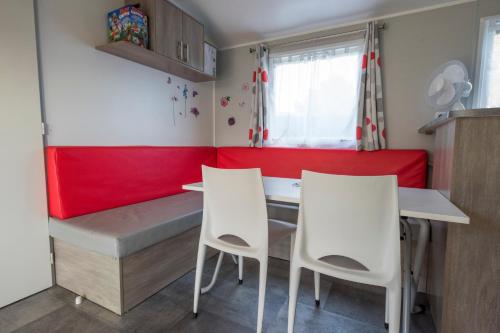 une petite cuisine avec une table et deux chaises dans l'établissement le 934 des charmettes, aux Mathes