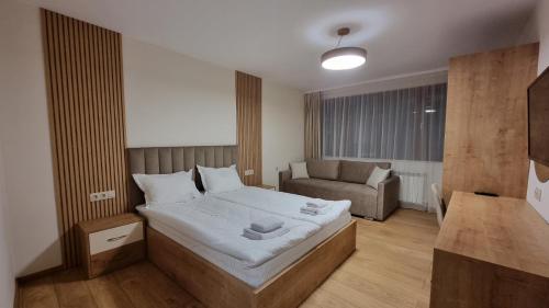 1 dormitorio pequeño con 1 cama y 1 sofá en Guest House Gogemi en Bansko