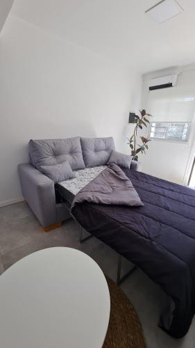 uma sala de estar com um sofá e uma cama roxa em Casa a estrenar equipada para 4 personas em Mar del Plata