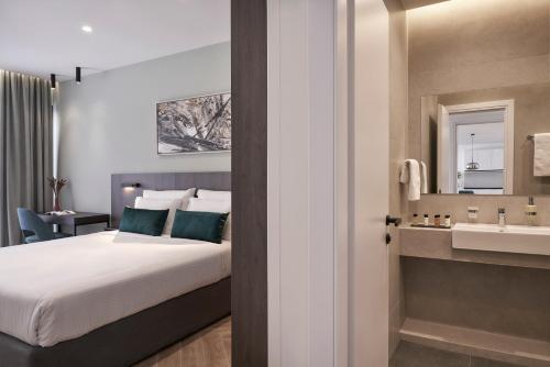 a bedroom with a bed and a bathroom with a sink at Hestia - Dimitressa 4 in Athens