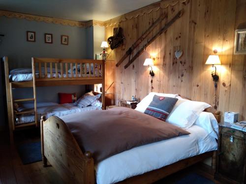 a bedroom with two beds and a wooden wall at La Grande Ourse in Campan