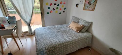 ein kleines Schlafzimmer mit einem Bett und einem Fenster in der Unterkunft chambre lit 2 personnes dans appartement du logeur in Mandelieu-la-Napoule