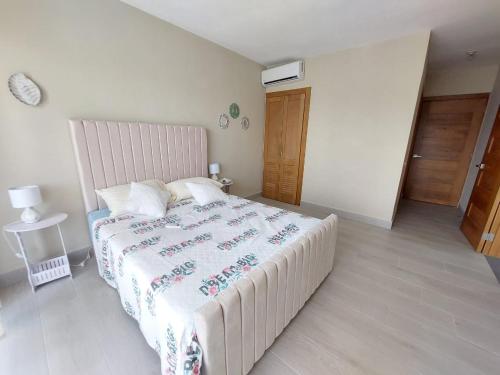 a bedroom with a large bed with a white bedspread at Residence Vibe Dominicus 308 in Bayahibe