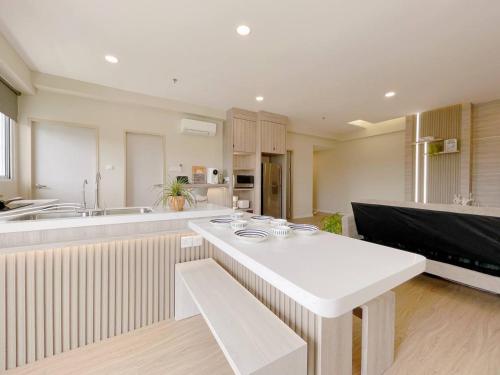 a large kitchen with a white table in a room at QUEENSLAND SUITES at Aru Suites, Kota Kinabalu in Kota Kinabalu