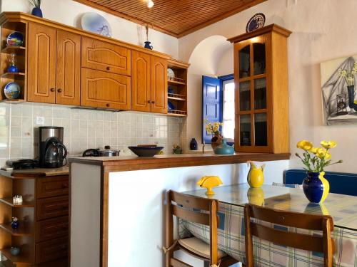 a kitchen with wooden cabinets and a table with chairs at Estelle in Khalkíon