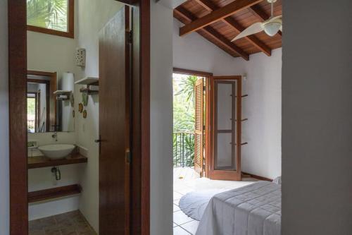 1 dormitorio con 1 cama y baño con lavamanos en CASA DA ILHA em CONDOMINIO, en Ilhabela