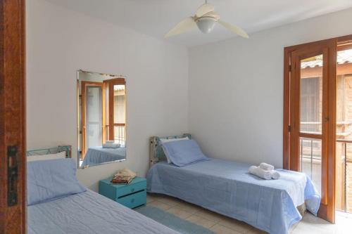 um quarto com 2 camas e um espelho em CASA DA ILHA em CONDOMINIO em Ilhabela