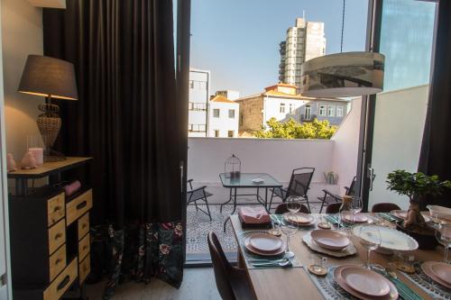 a dining room with a table and chairs and a window at Birds Apartments in Porto