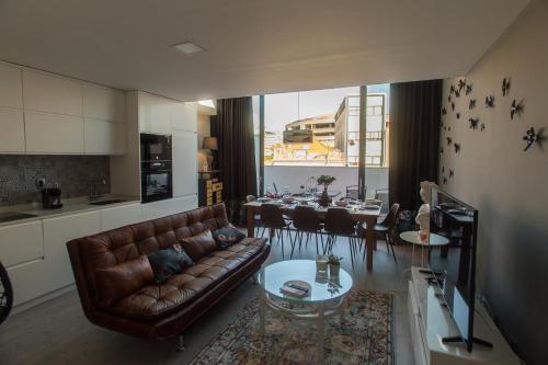 a living room with a leather couch and a table at Birds Apartments in Porto