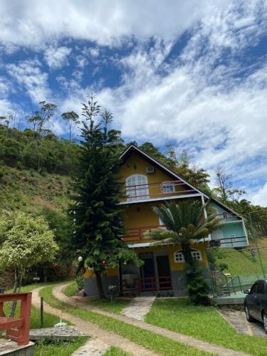 a yellow house with a tree in front of it at Hotel Fazenda Bonanza in Engenheiro Paulo de Frontin