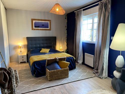 a blue bedroom with a bed and a chair at grande villa familiale in Saint-Pair-sur-Mer