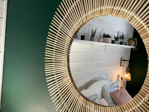 a mirror with a wicker frame on a wall at grande villa familiale in Saint-Pair-sur-Mer