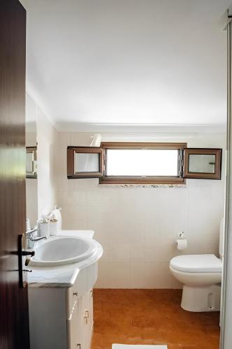 a white bathroom with a sink and a toilet at Casa Bela Vista de Moledo in Moledo