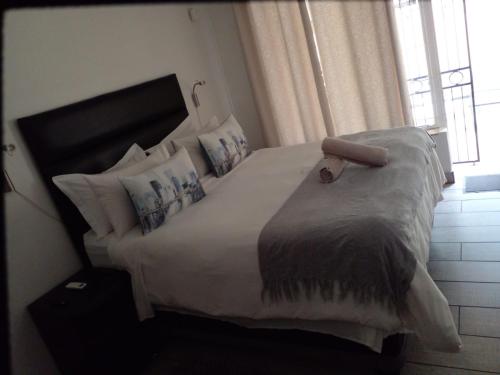 a bedroom with a large bed with white sheets and pillows at LightStone Guesthouse in Centurion