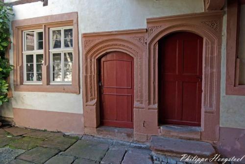 duas portas vermelhas e janelas num edifício em Maison Kobold XVIè siècle em Wissembourg