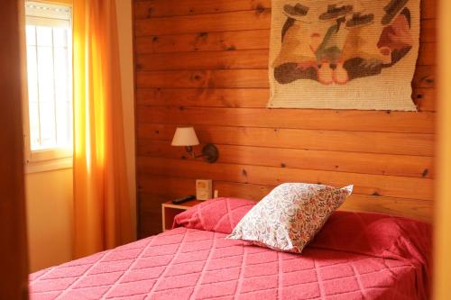 un dormitorio con una cama con un edredón rosa en el Laberinto Gesell de Villa Gesell