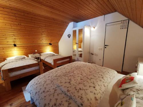 - une chambre avec 2 lits et un mur en bois dans l'établissement Chalet Via Mons, à Mojstrana