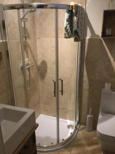 een badkamer met een douche, een wastafel en een toilet bij 3 BEDROOM 5* BARN CONVERSION COTSWOLDS in Chipping Norton