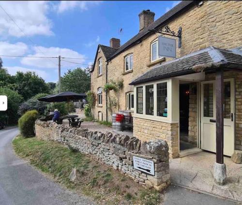 a man sitting at a table outside of a building at 3 BEDROOM 5* BARN CONVERSION COTSWOLDS in Chipping Norton