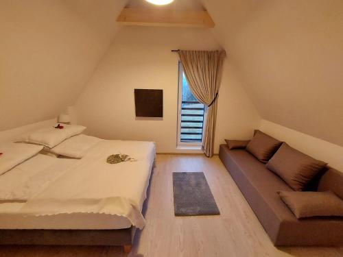 a bedroom with a bed and a couch at Chałpy Na Wierchu in Rzepiska