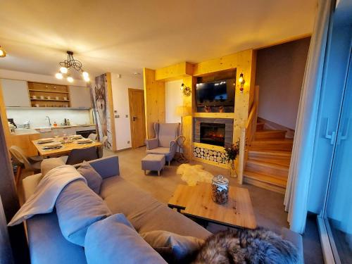 a living room with a couch and a fireplace at Chałpy Na Wierchu in Rzepiska