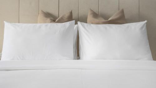 two white pillows sitting on top of a bed at Shintana Saya La Maison in Siem Reap