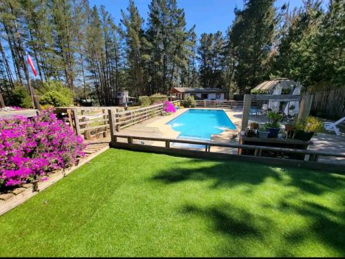 un patio trasero con una valla y una piscina en Cabañas Renacer en Casa Grande - Algarrobo, en Algarrobo