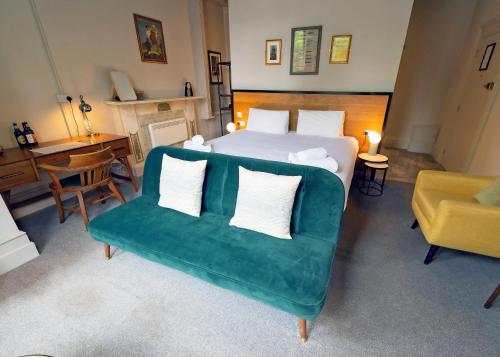 a bedroom with a bed and a green couch at The Georgian Townhouse in Norwich