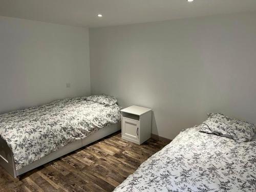 een slaapkamer met 2 bedden en een nachtkastje bij Bel appartement T3 proximité centre et commerces in Pélussin