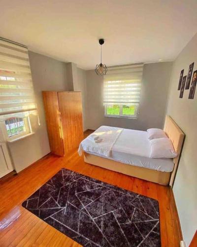 een slaapkamer met een bed met een zwart tapijt bij Sapanca voyage2 havuzlu müstakil villa in Sapanca