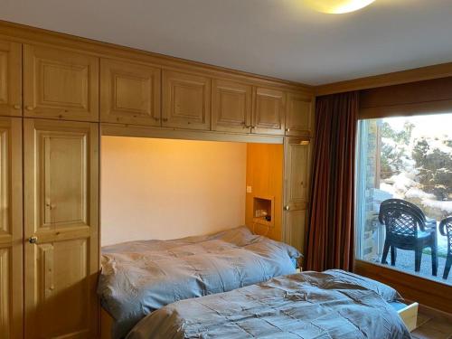 a bedroom with a bed next to a window at Garden Studio Apartment Crans Montana in Crans-Montana