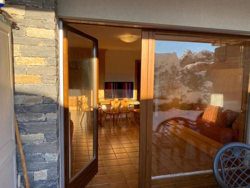 a sliding glass door leading to a patio with a table at Garden Studio Apartment Crans Montana in Crans-Montana