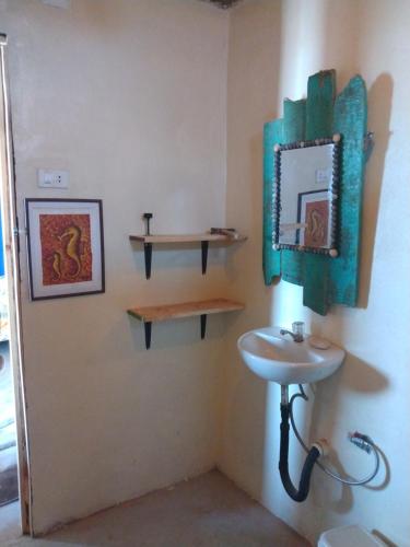 a bathroom with a sink and two shelves on the wall at La Casa del Naufrago in Lobitos