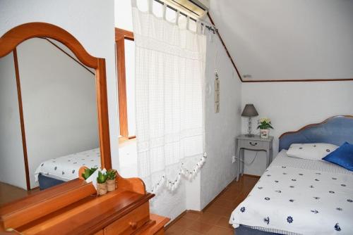 a bedroom with a mirror and a bed and a window at Mansarda apartment in Kotor