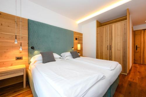 - une chambre avec un grand lit blanc dans l'établissement Bepy Hotel Garni, à Giustino
