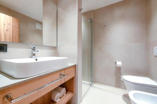 La salle de bains est pourvue d'un lavabo et d'une douche. dans l'établissement Bepy Hotel Garni, à Giustino